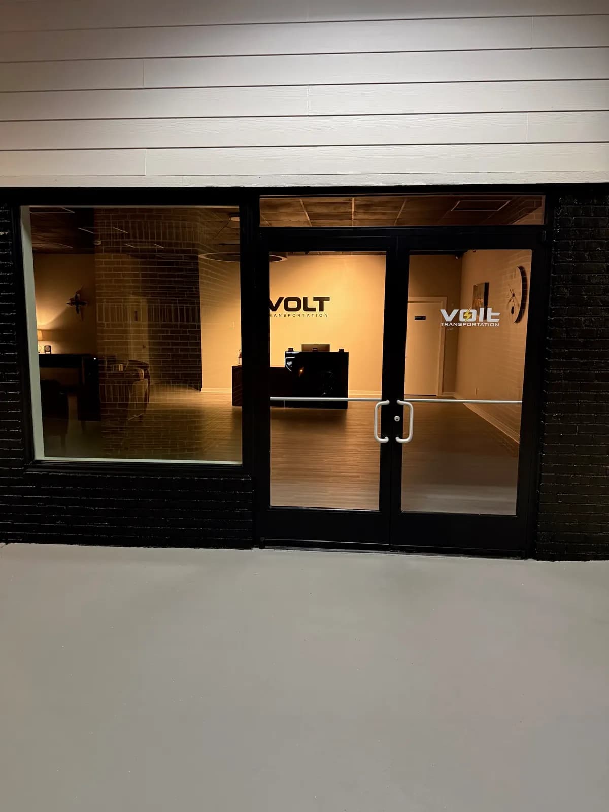 The lit Volt Transportation lobby seen through the front doors at night
