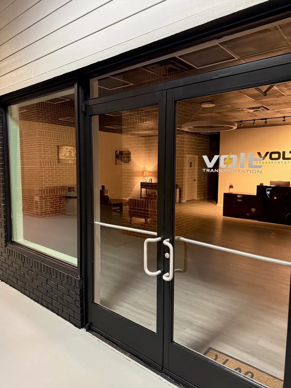 Glass entrance doors to the Volt Transportation lobby in Suite C